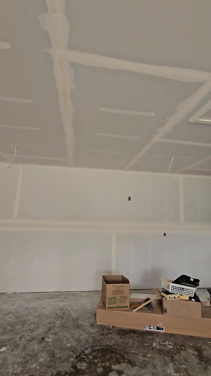 Taped drywall seams across walls and ceiling