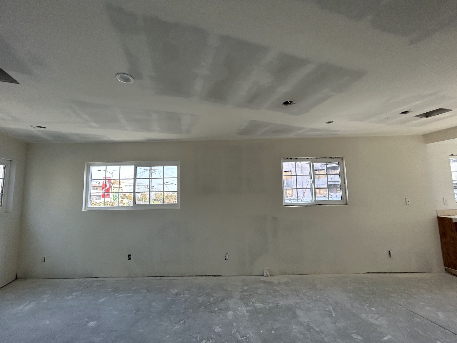 Finished room with smooth drywall and trimmed windows